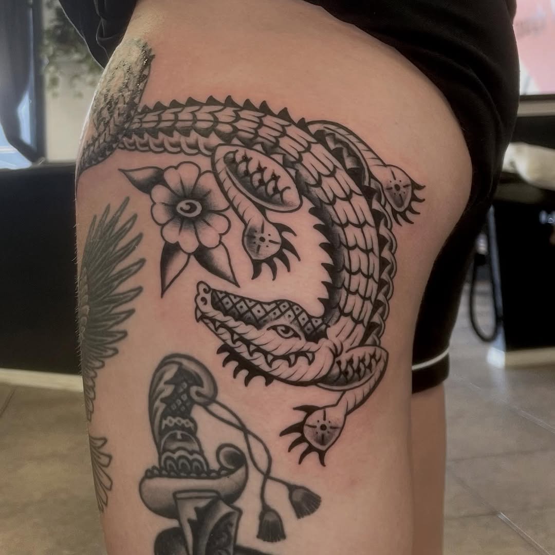 Bold blackwork dragon coils around a flower accent.