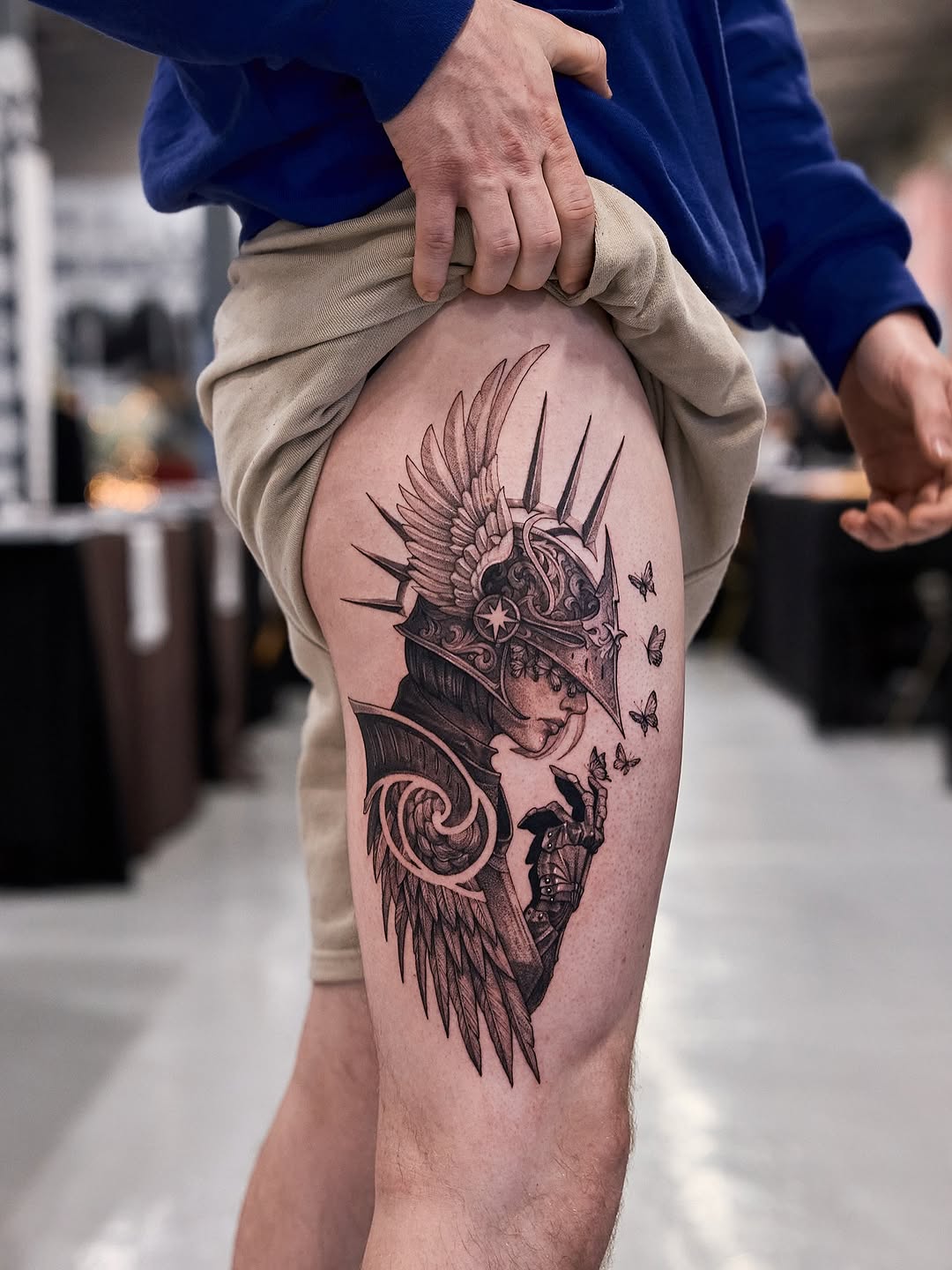 Winged armored figure with ornate helm and fluttering butterflies