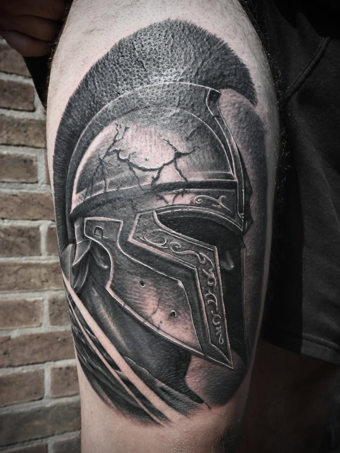 Realistic black-and-gray Spartan helmet with weathered cracks