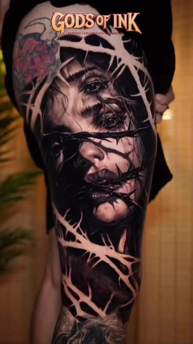 Hyper-realistic black-and-gray portrait wrapped with barbed wire
