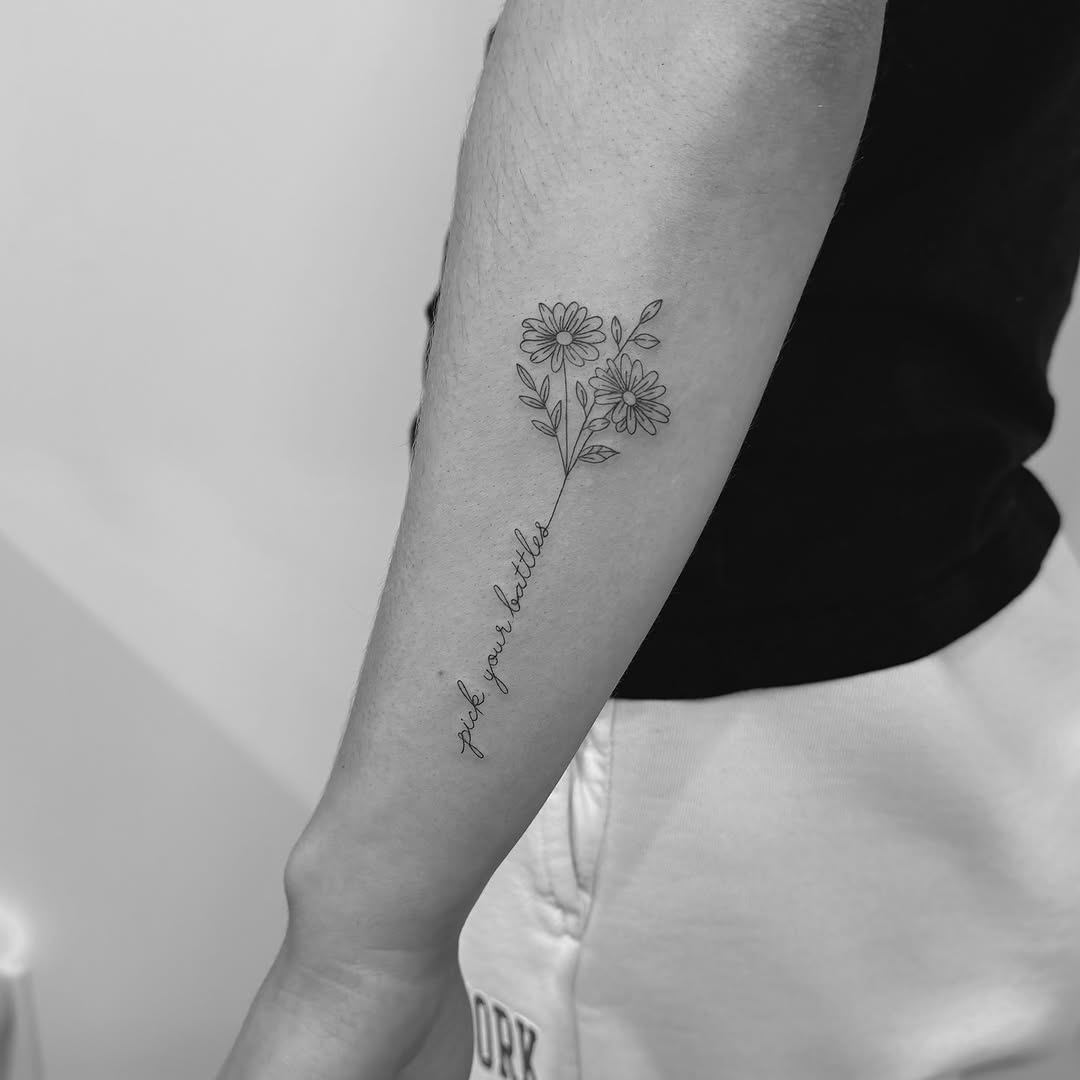 Delicate floral stem with daisy-like blooms and cursive script