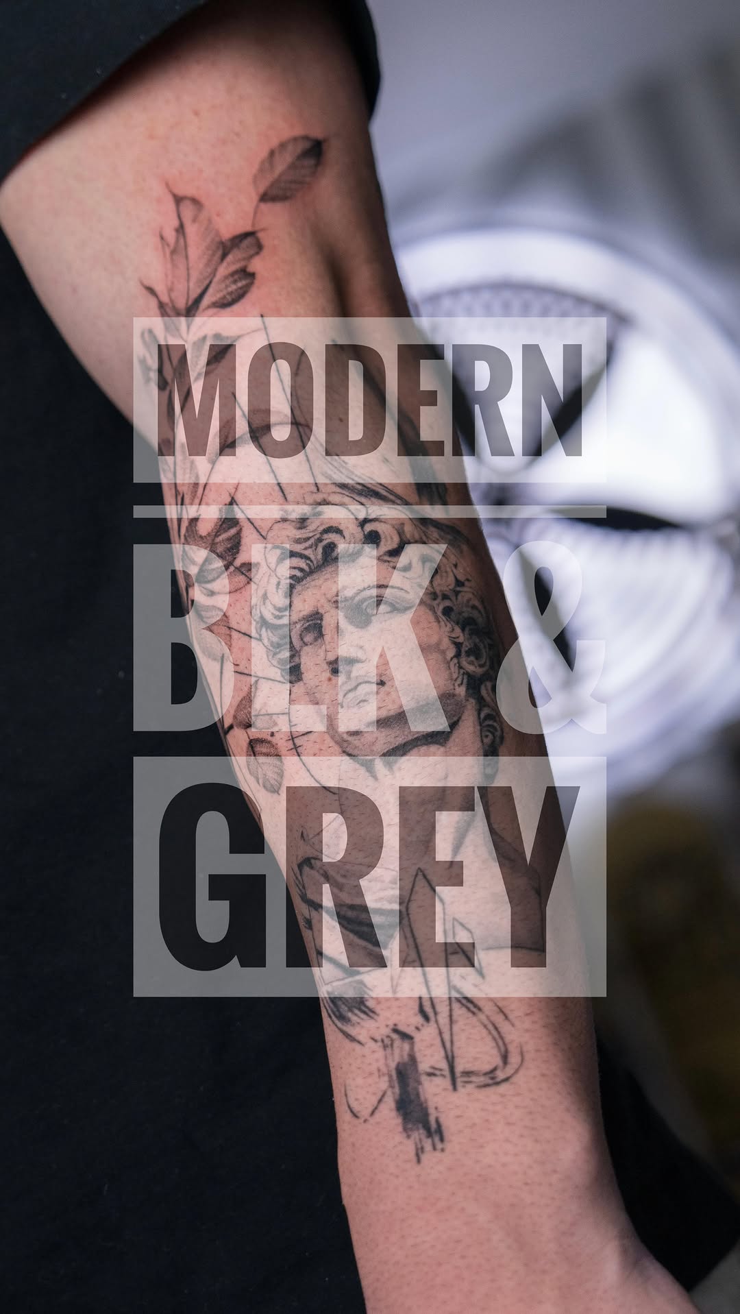 Intricate black-and-gray botanical sleeve with shaded portrait