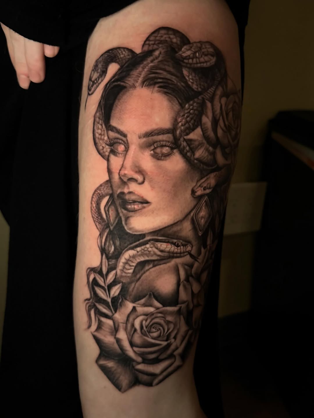 Hyper-detailed black-and-gray realism portrait with snakes and roses.