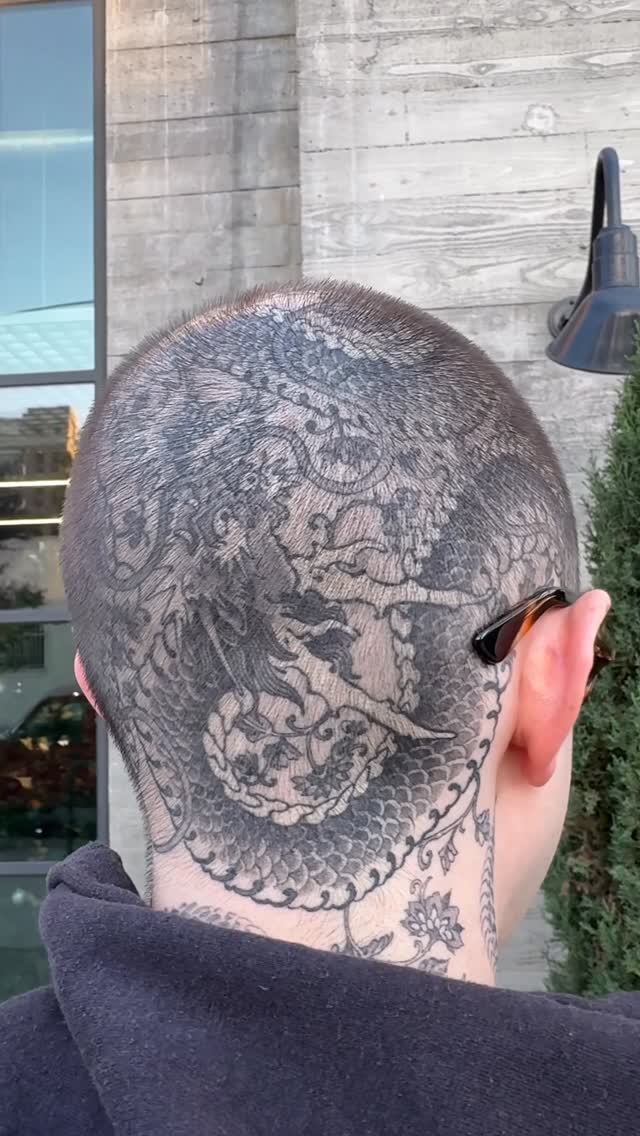 Intricate black dragon coils around the neck in scale-dense shading.