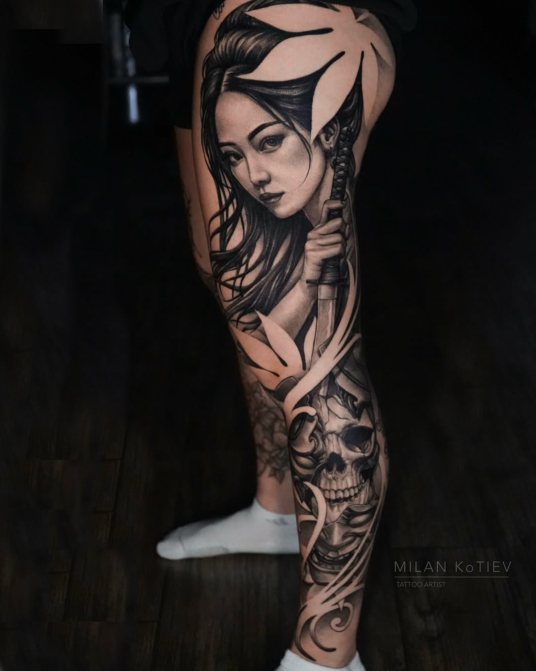 Bold black-and-gray leg sleeve with female portrait and skull