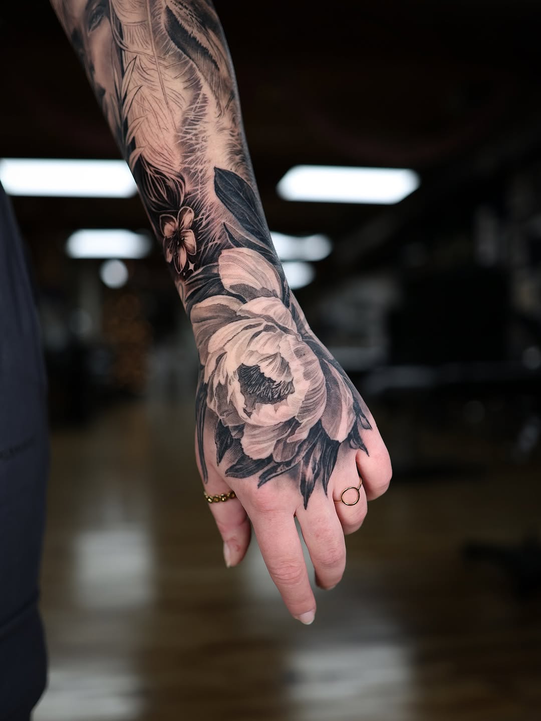 Bold black-and-gray peony on hand with lush shading