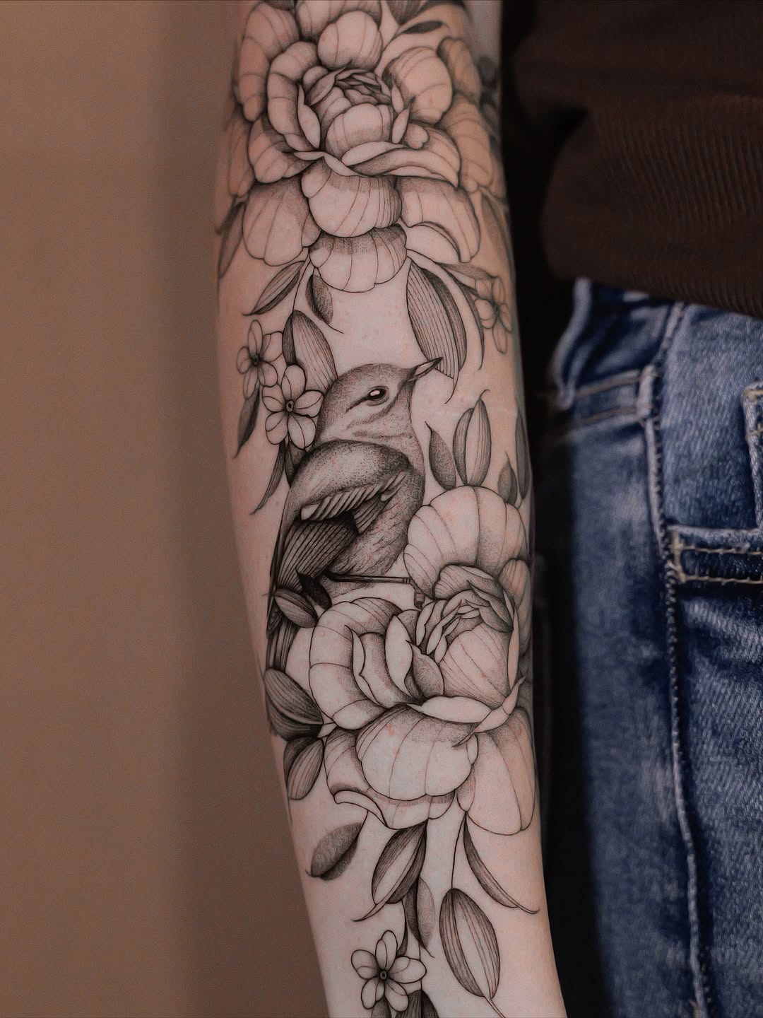 Delicate blackline florals frame a perched bird in ink