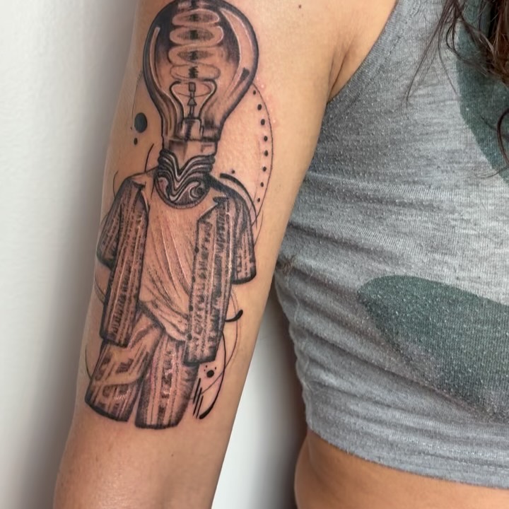 Abstract humanoid with lightbulb head and timber torso.