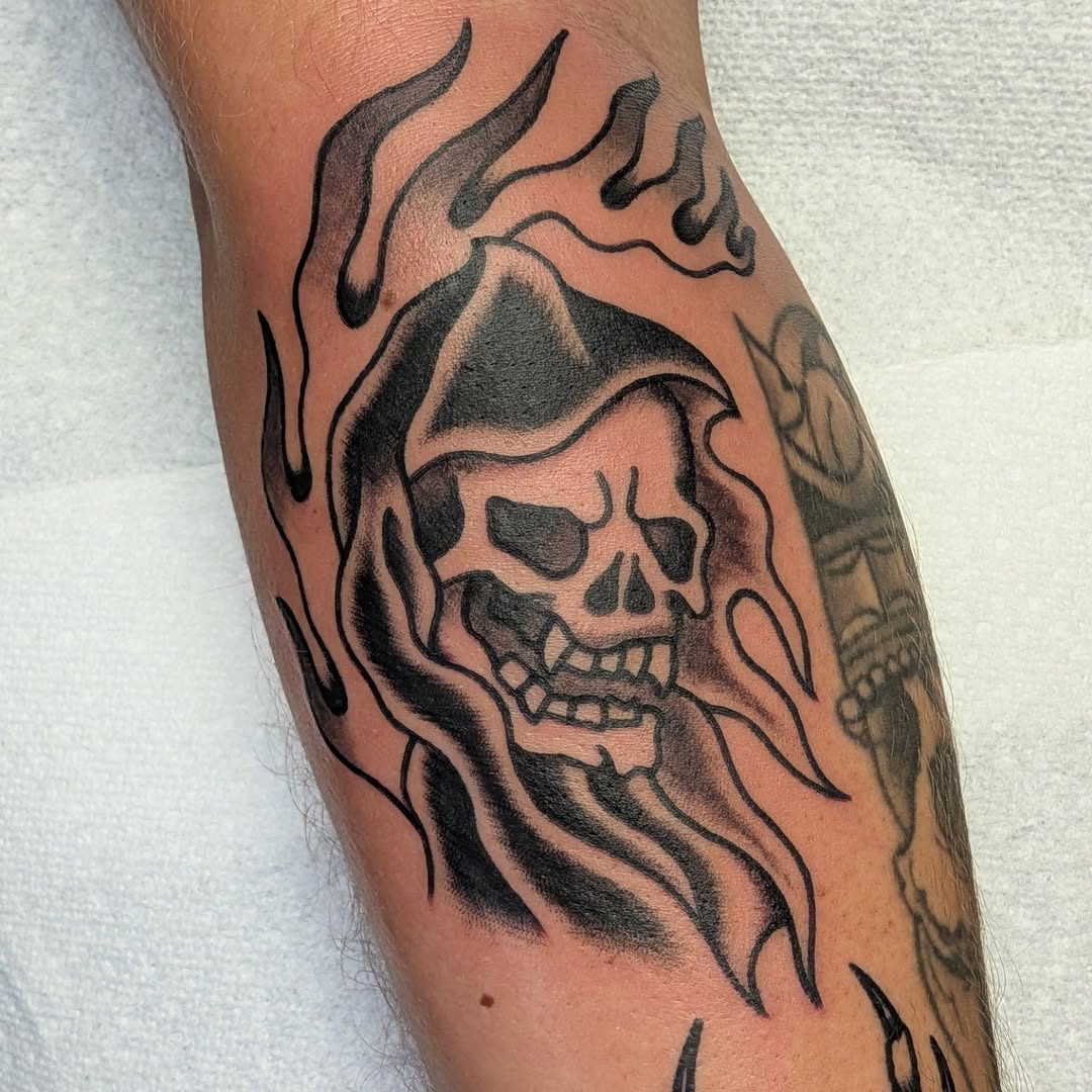 Bold blackwork skull surrounded by curling flame wisps