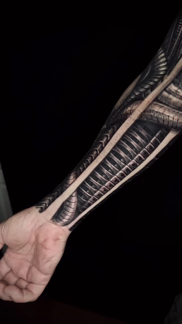 Hyper-detailed biomechanical forearm sleeve with ribbed textures.