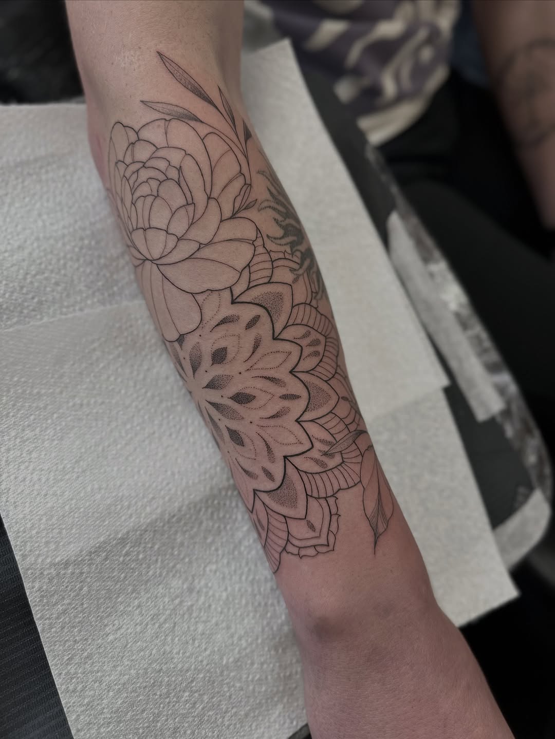 Intricate floral mandala with layered petals on forearm