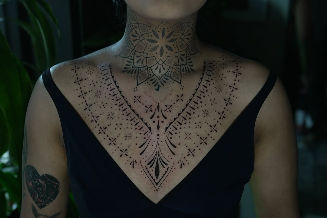 Intricate blackwork mandala chest piece with dotwork accents