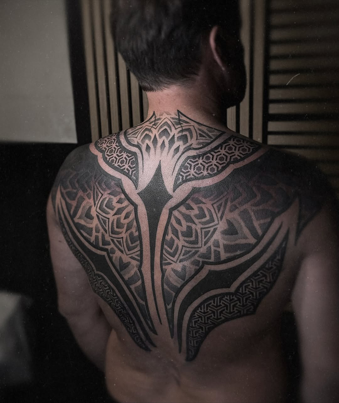 Intricate blackwork back piece with interlocking geometric patterns.