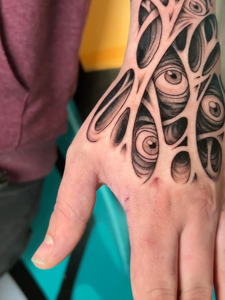 Monochrome blackwork hand piece studded with floating eyes.