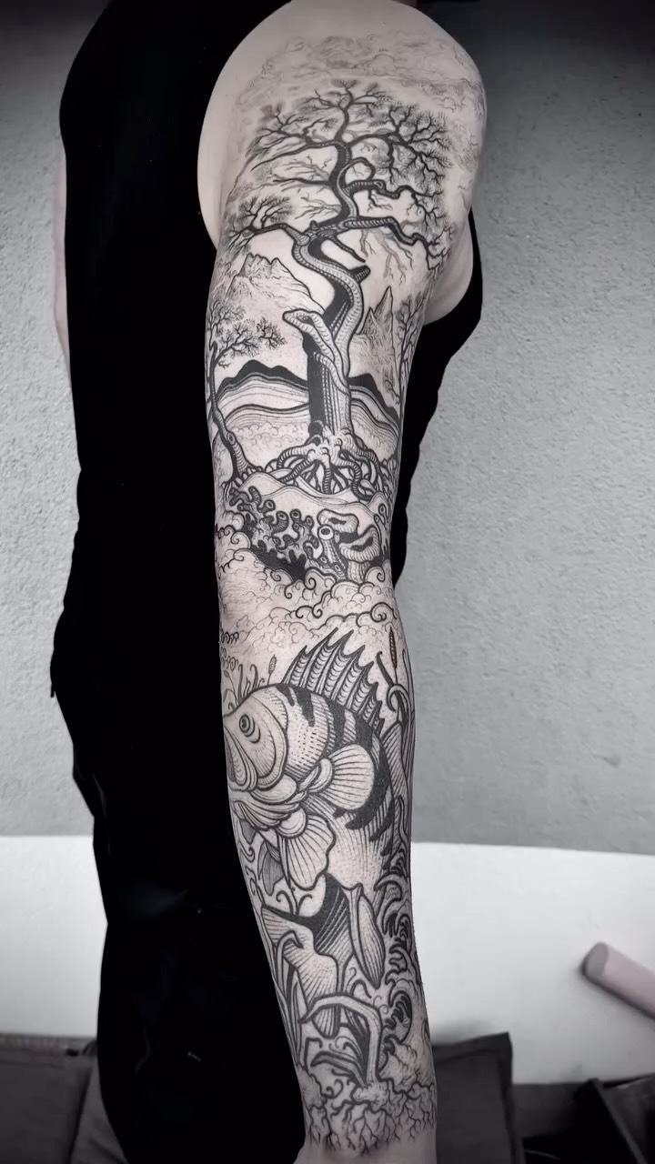 Monumental black-and-gray sleeve with a twisting tree, waves, and fish.