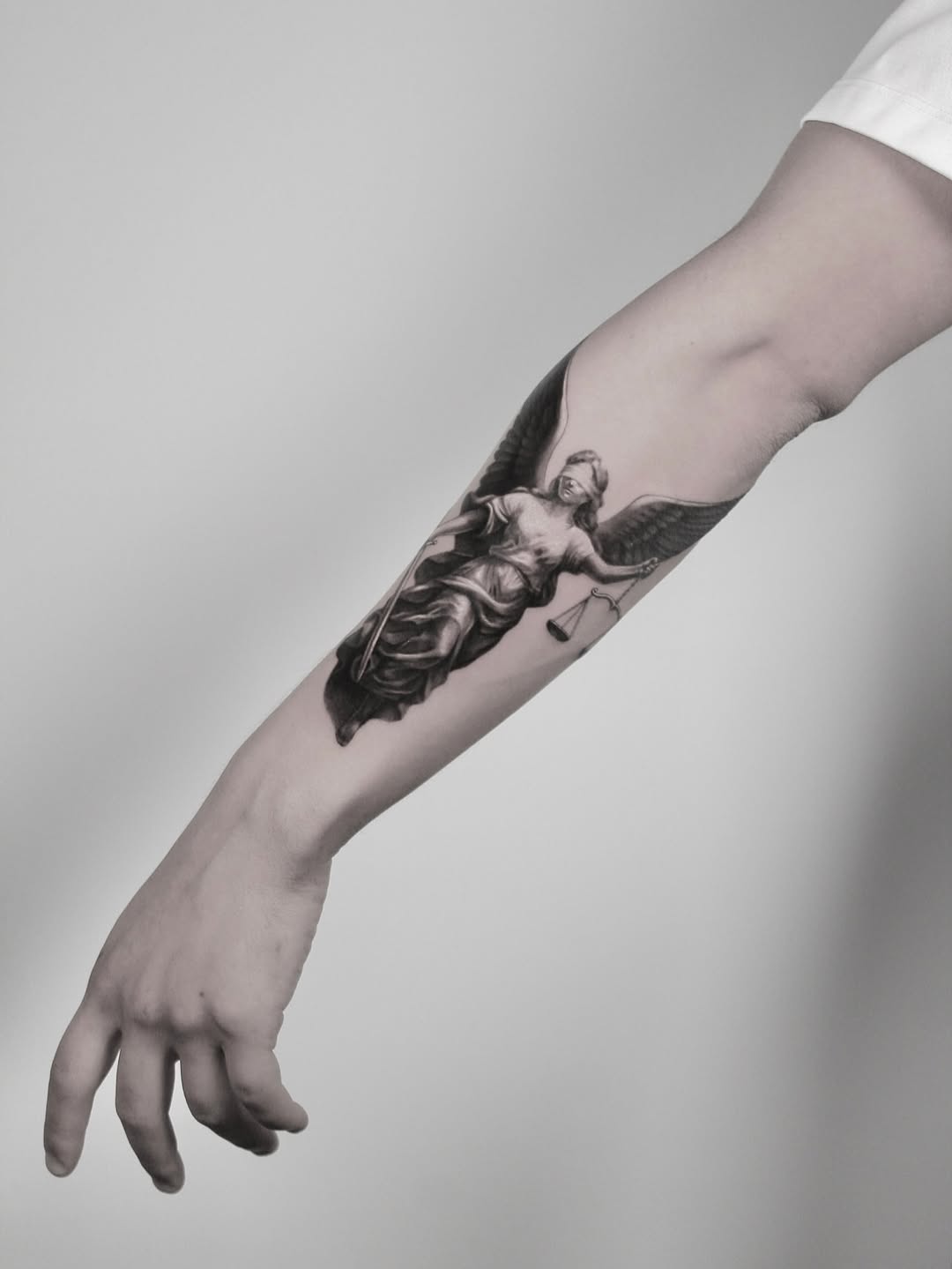 Intricate black-and-gray angel with scales tattoo