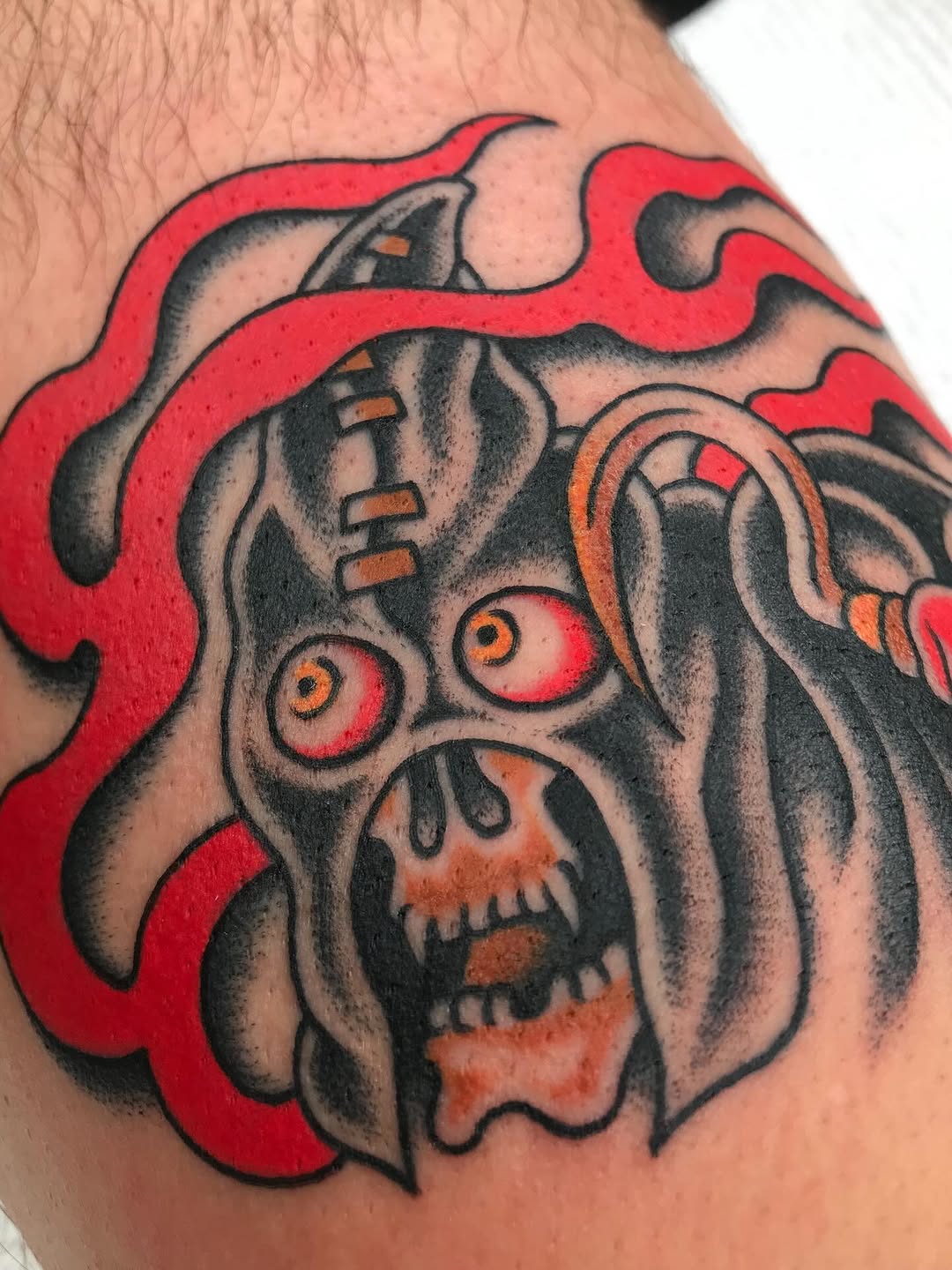 Bold neo-traditional skull-faced demon with fiery red accents