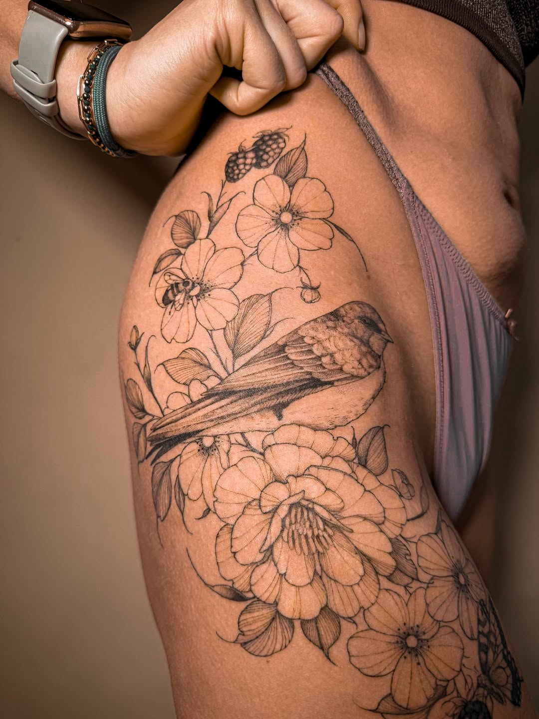 Delicate swallow amid blooming florals in fine-line style.