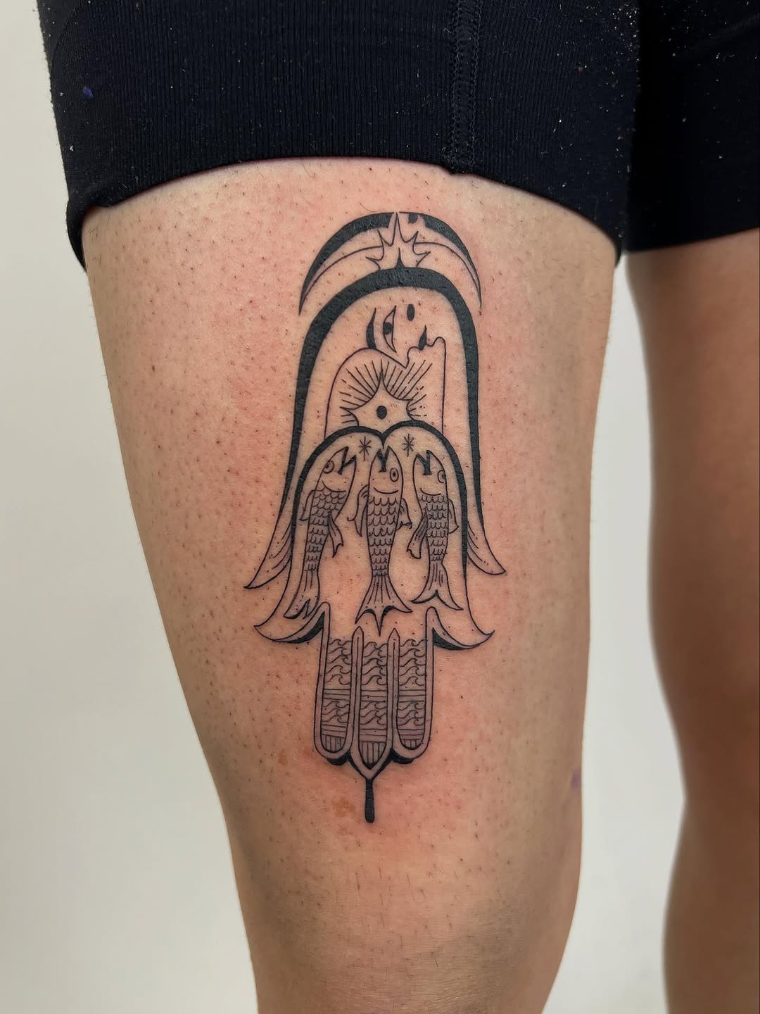 Bold linework talisman featuring three koi within arch.