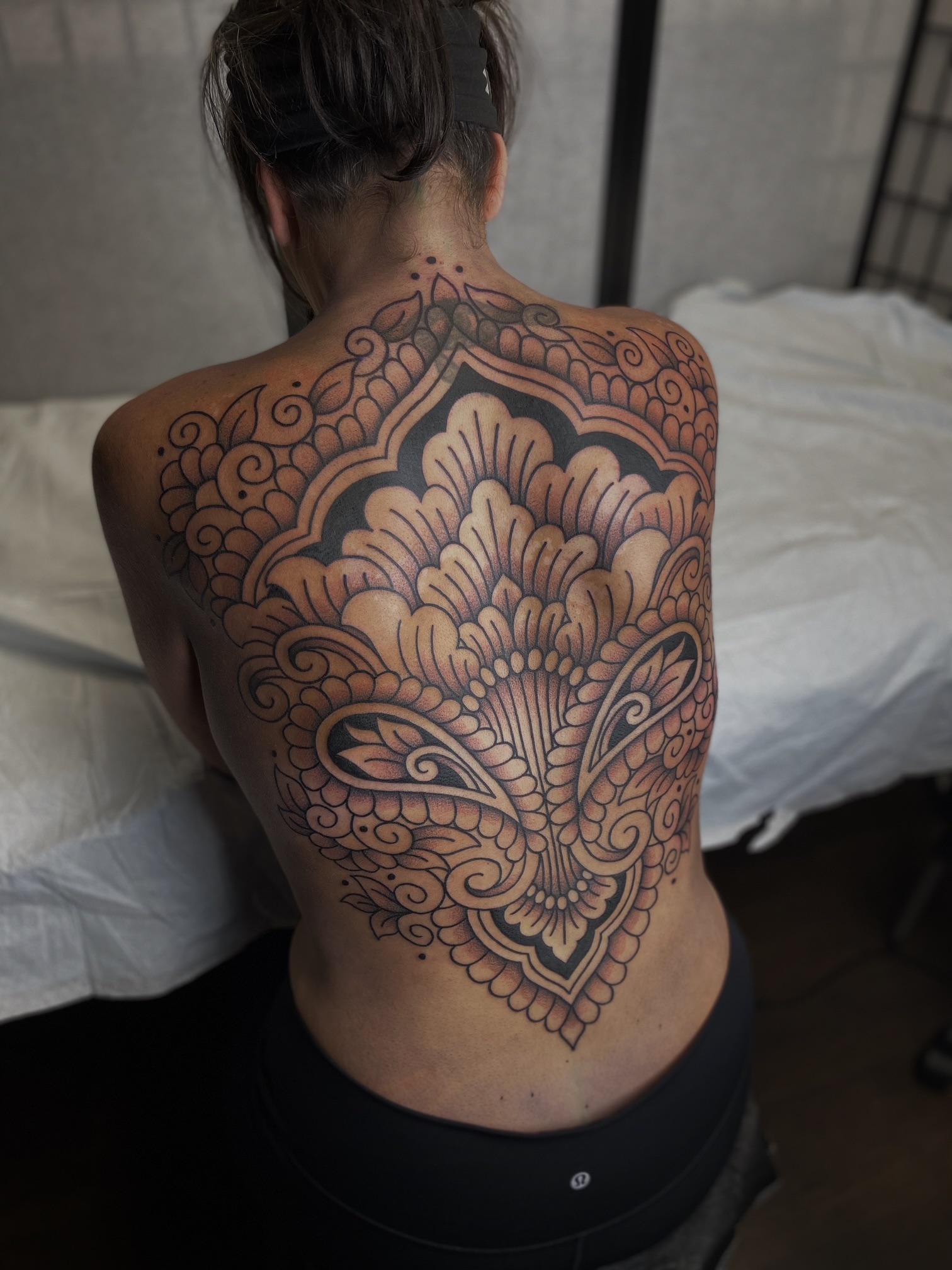 Intricate blackwork mandala back piece with ornate floral filigree