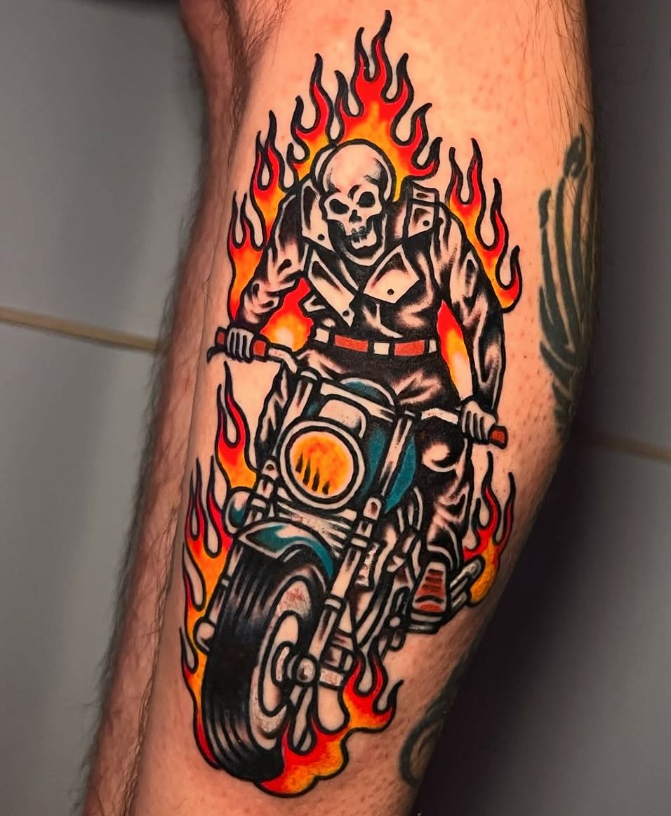 Bold traditional skull biker on flaming motorcycle.