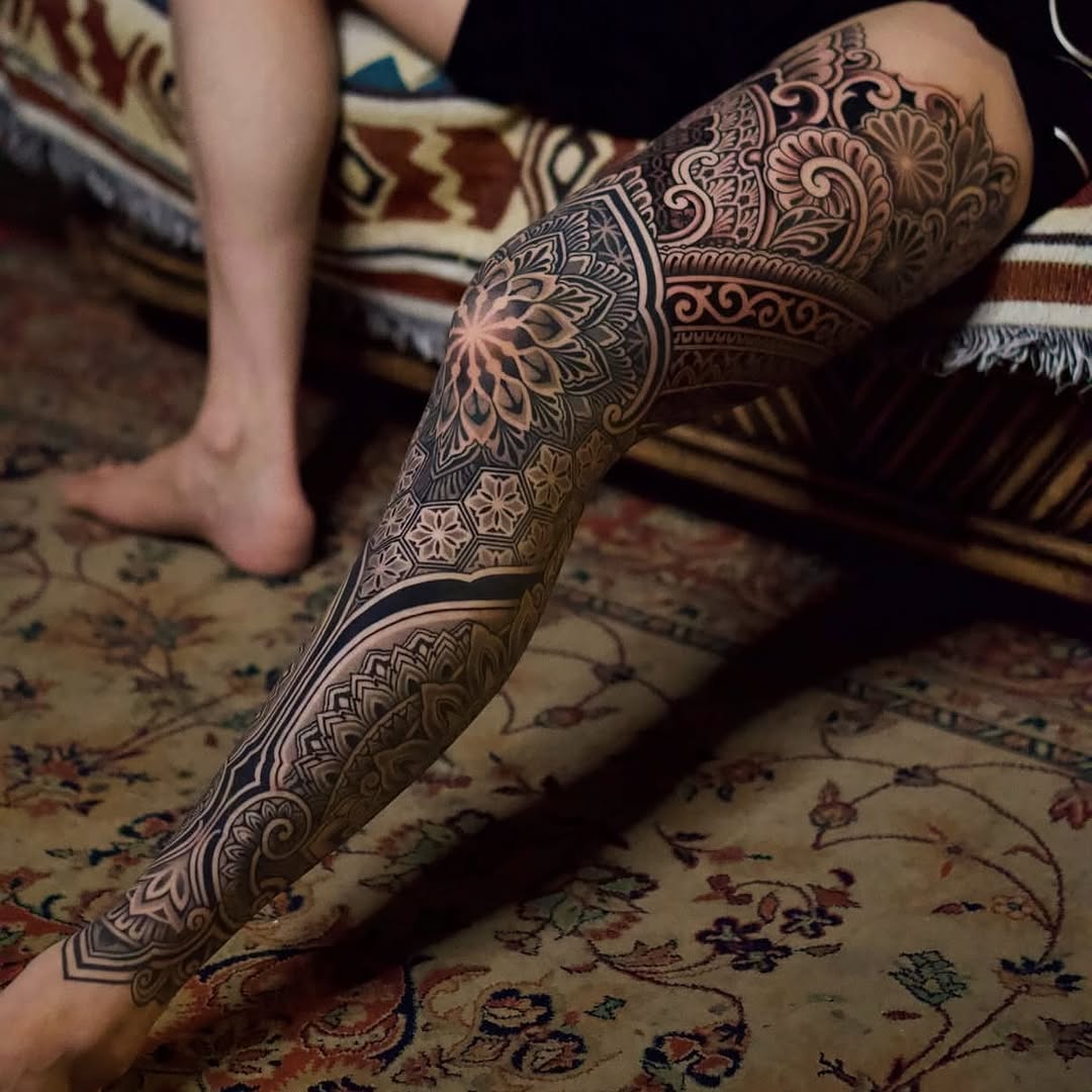 Intricate blackwork mandala leg-sleeve with bold geometry.