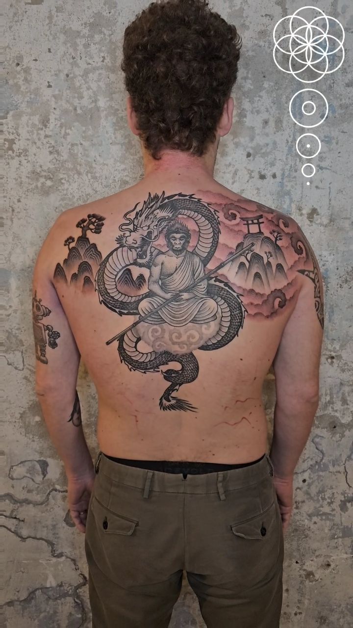 Sweeping blackwork dragon encircles Sun Wukong amid mountains