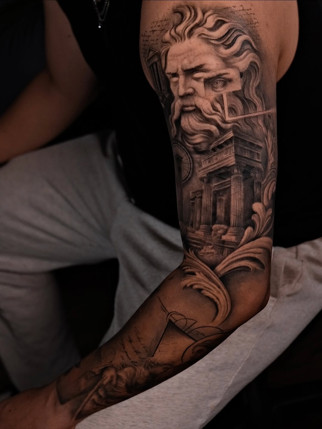 Monochrome classical-sculpture sleeve with pillars, archways, and mythic visage