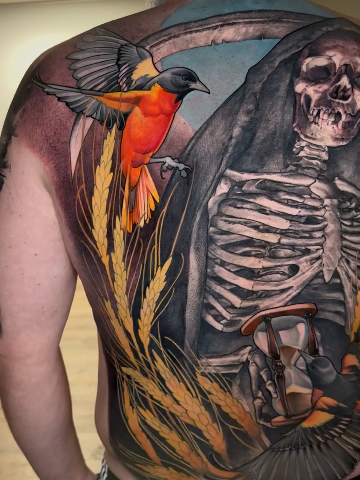Vibrant backpiece: vivid oriole, skeletal figure, hourglass motif