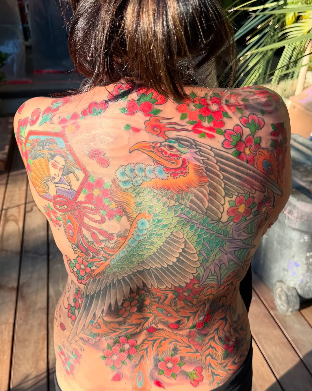 Vibrant back piece: phoenix-dragon with cherry blossoms and geisha