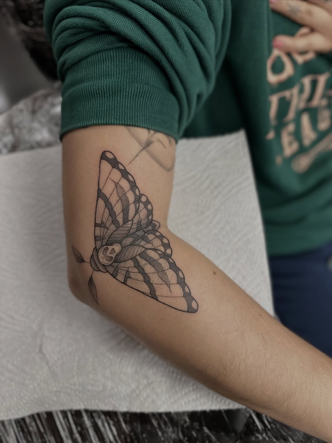 Intricate black moth tattoo with fine-line and dotwork
