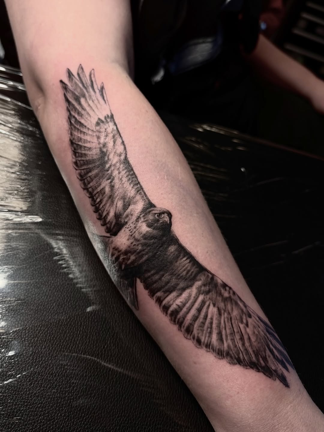 Hyper-realistic red-tailed hawk with outstretched wings.