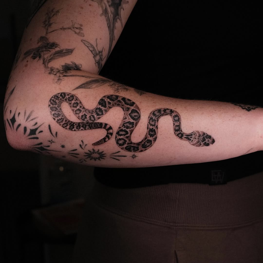 Fine-line diamondback rattlesnake with bold blackwork shading.