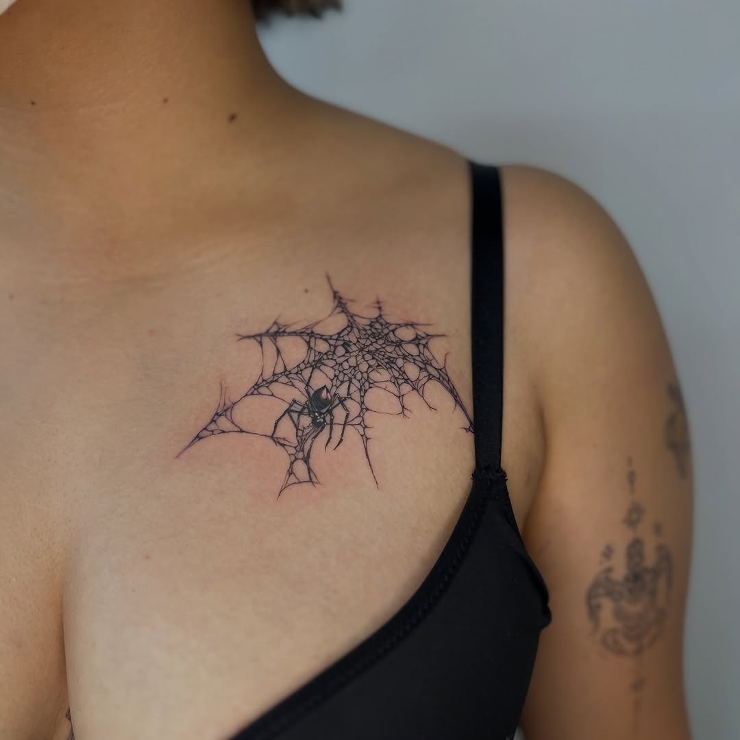 Delicate spider-web tattoo with a tiny spider