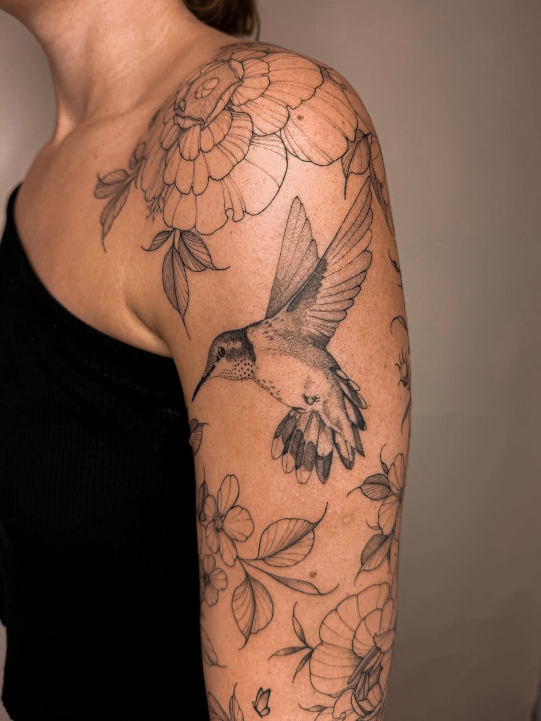 Intricate floral sleeve with perched hummingbird in fine linework