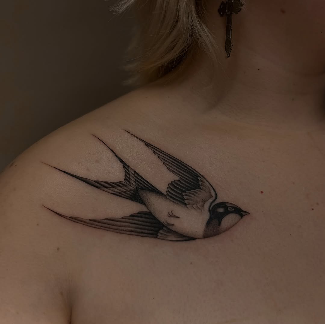 Fine-line swallow gliding across the collarbone