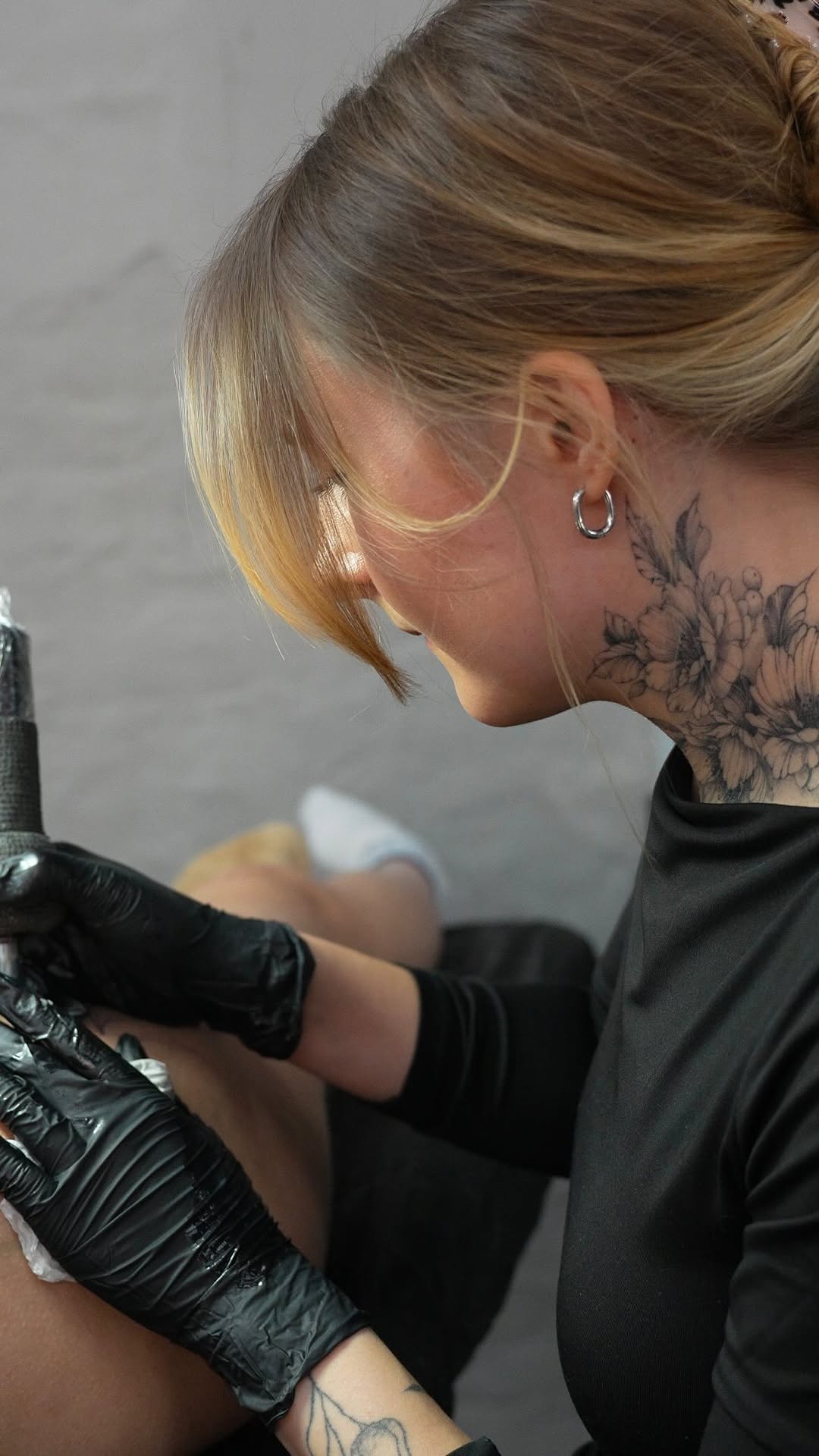 Delicate floral neck tattoo in fine-line botanical style