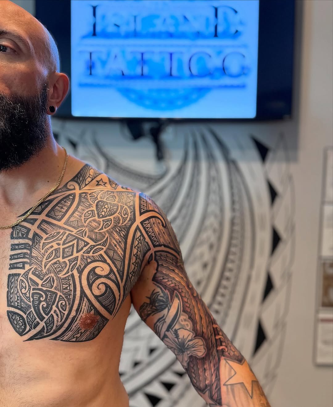 Intricate Polynesian blackwork sleeve across chest and arm.
