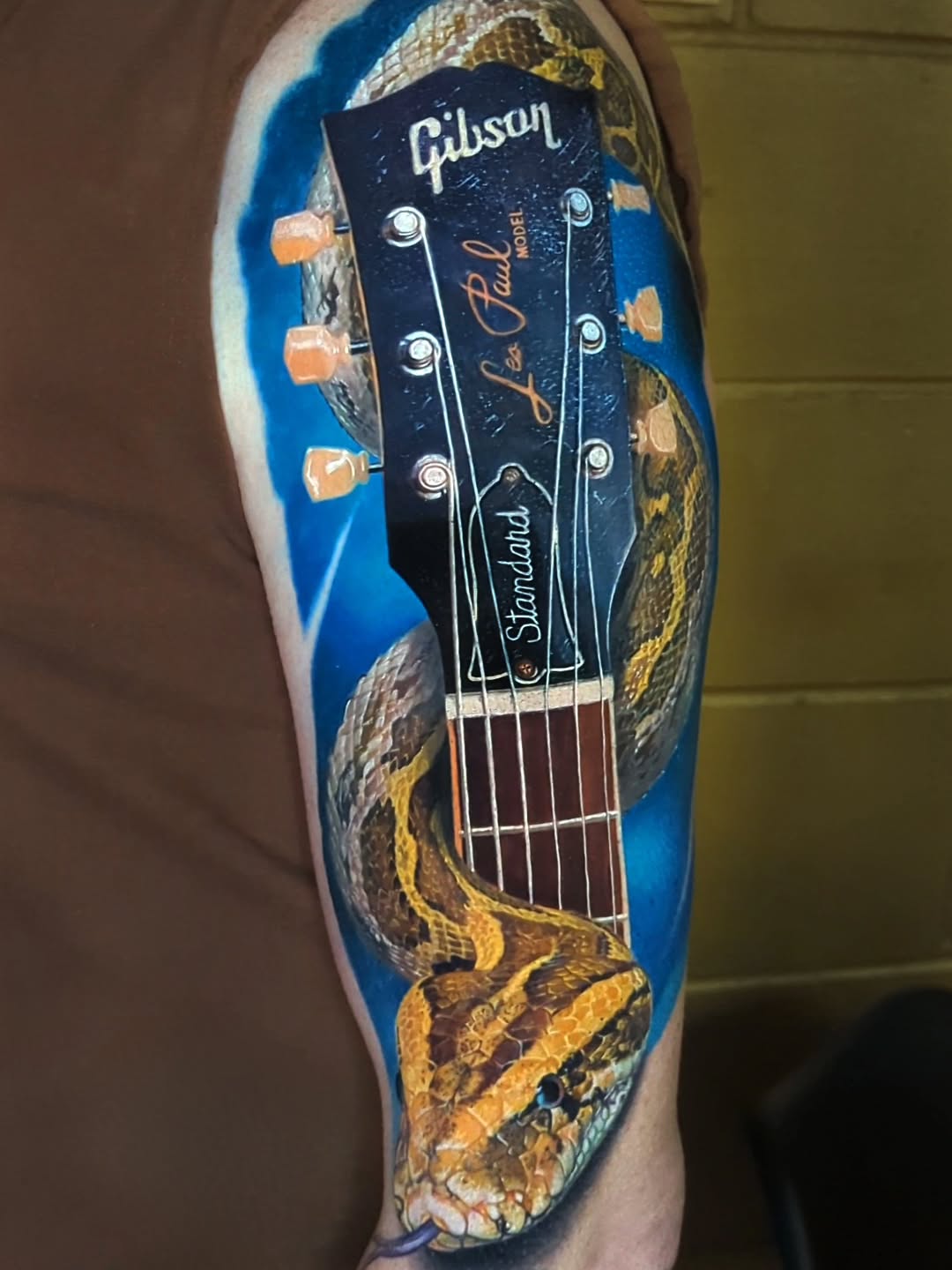 Hyperrealistic snake entwined with Gibson Les Paul headstock