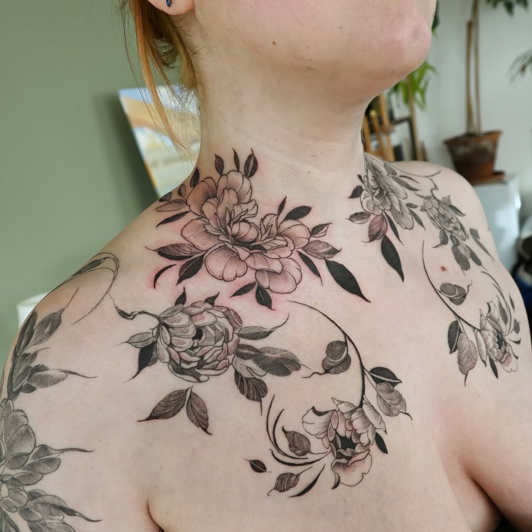 Elegant black-and-gray floral cascade across collarbone and shoulder