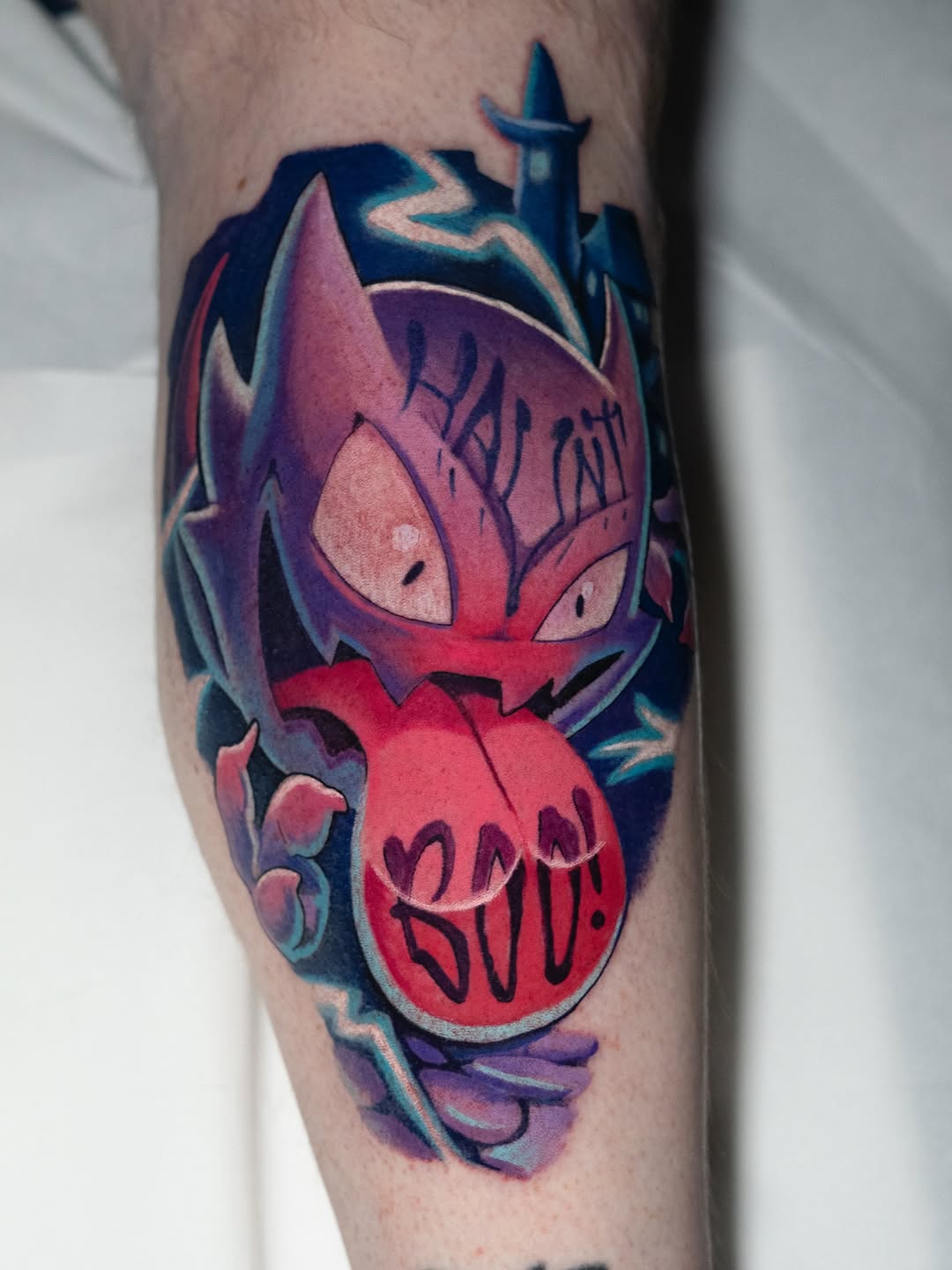 Vibrant cartoon monster tattoo with bold lines and BOO