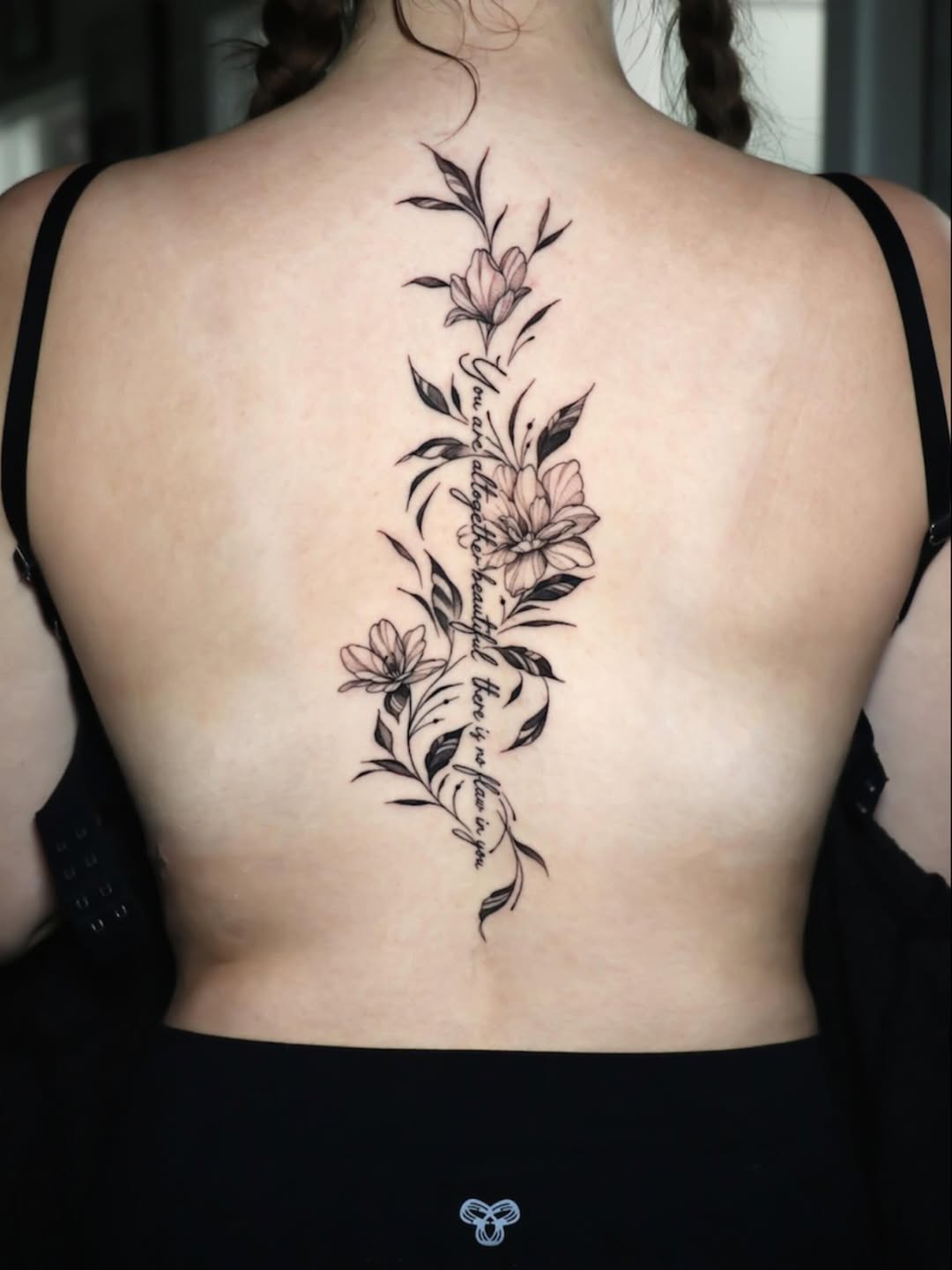 Elegant vertical floral spine piece in fine-line blackwork