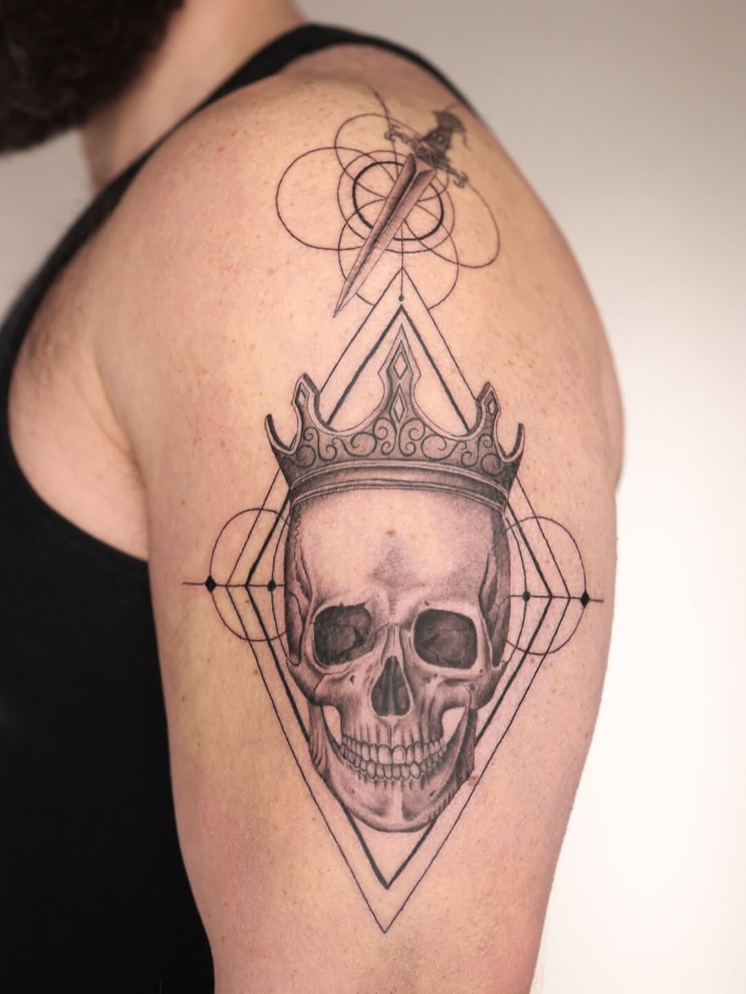 Crowned skull within geometric diamonds and dagger arcs