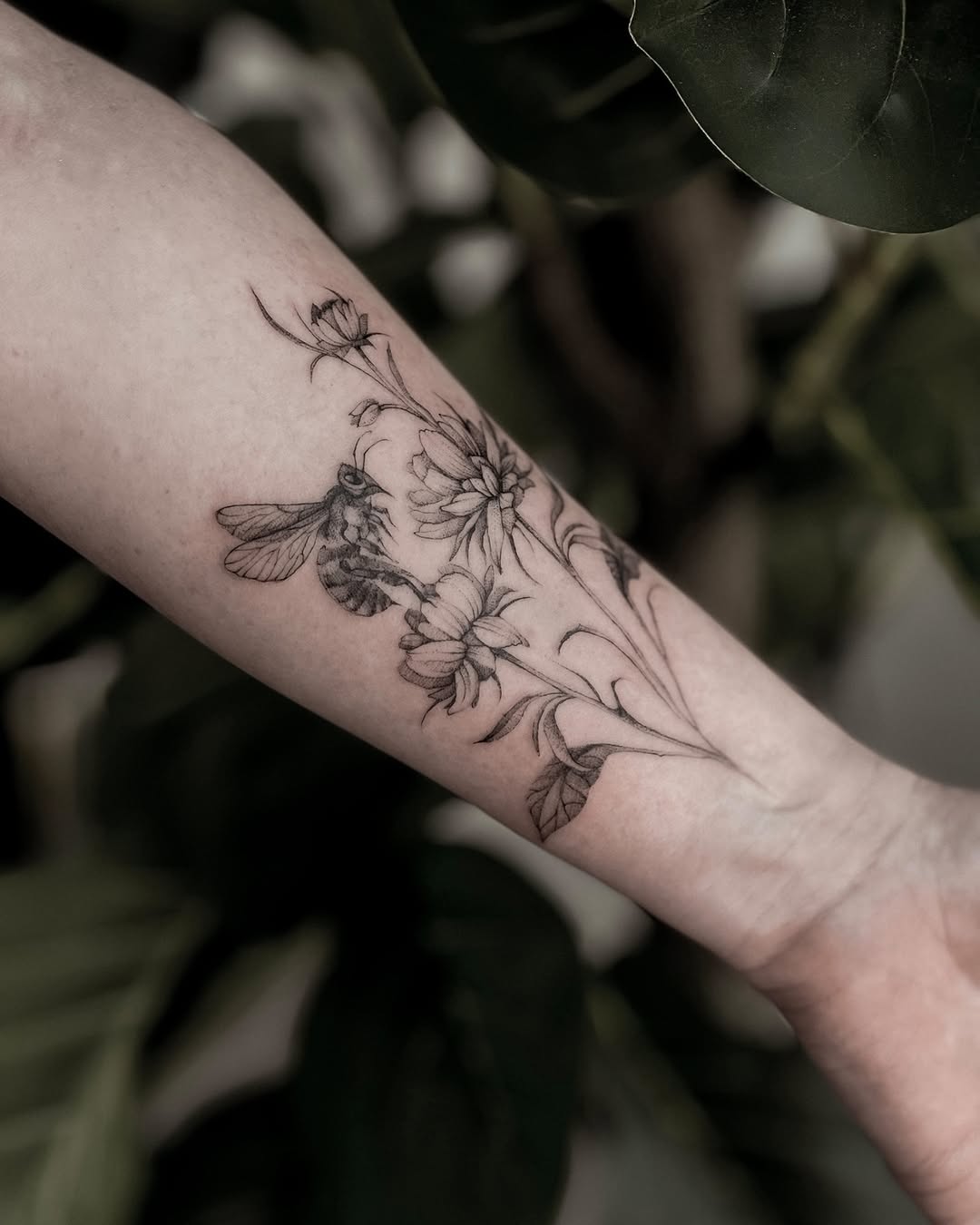 Delicate floral vine in fine-line with a bee