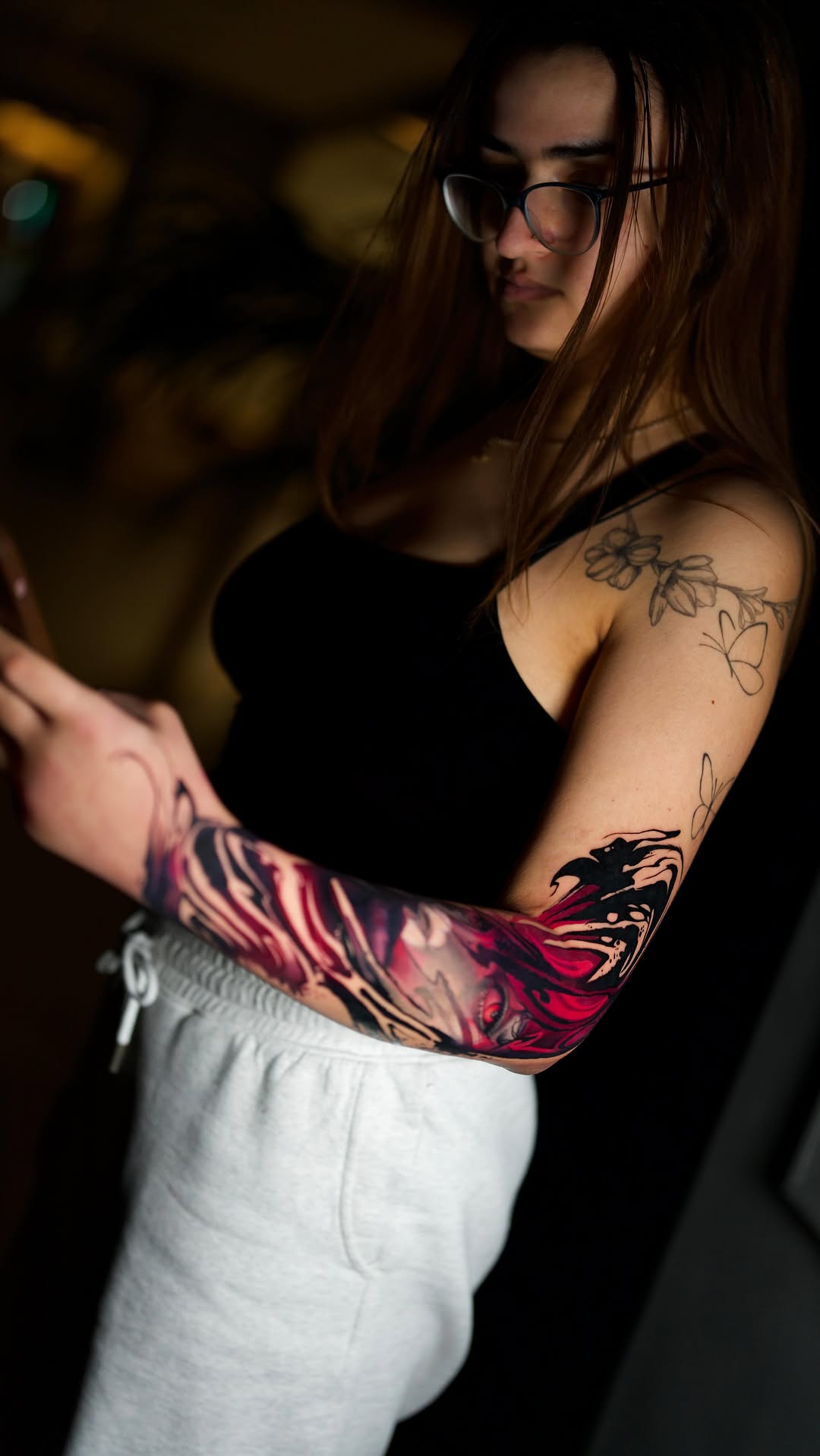 Vibrant neon-red and black sleeve contrasts with delicate floral shoulder