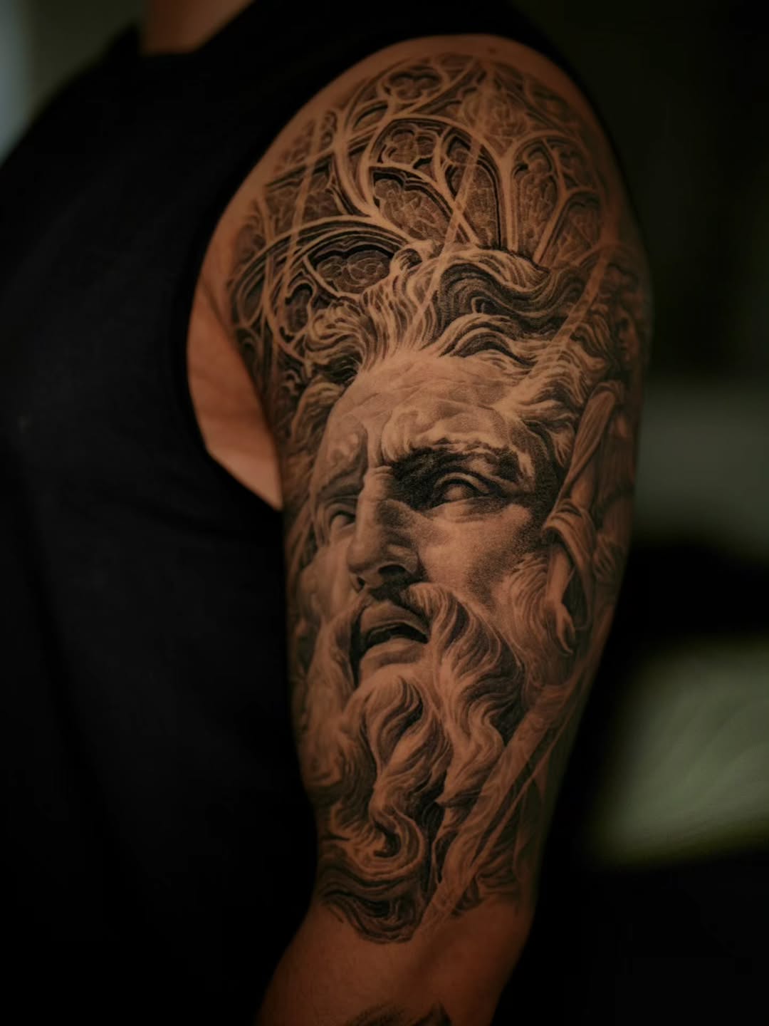 Striking black-and-gray portrait of a classical bearded god