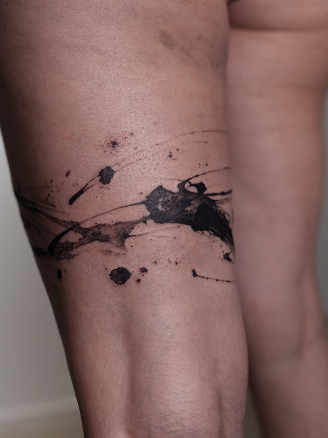 Bold abstract brushstroke bracelet wraps the arm.