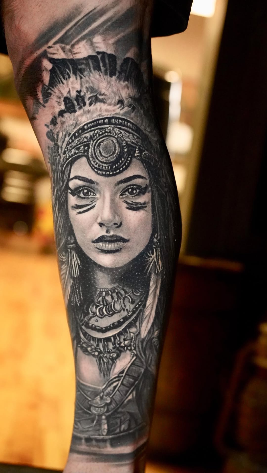 Striking grayscale portrait on forearm with ornate headdress