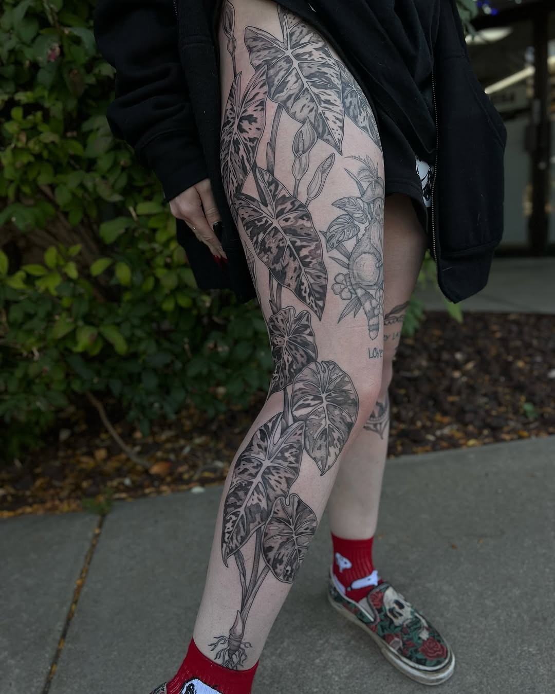 Elaborate black-and-gray botanical leg piece with alocasia leaves