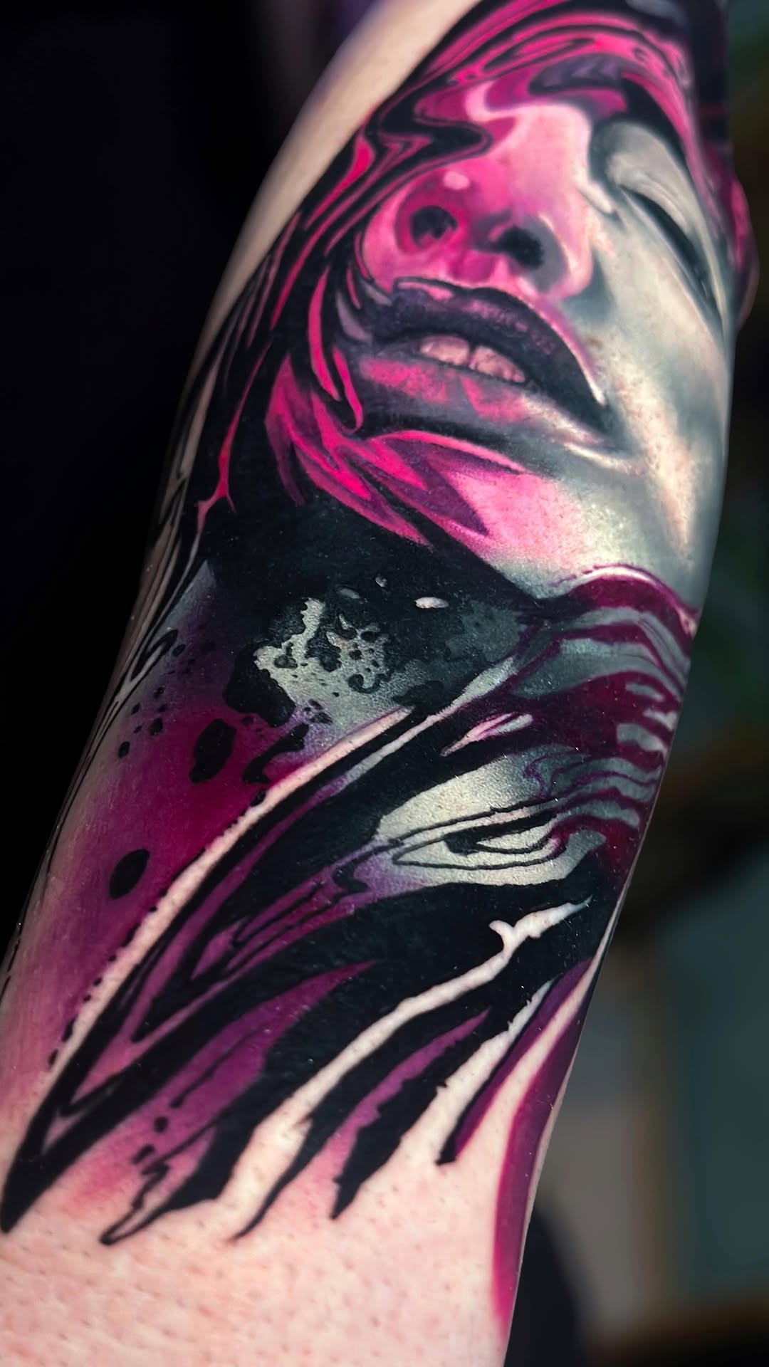 Neon pink and black abstract portrait on forearm.